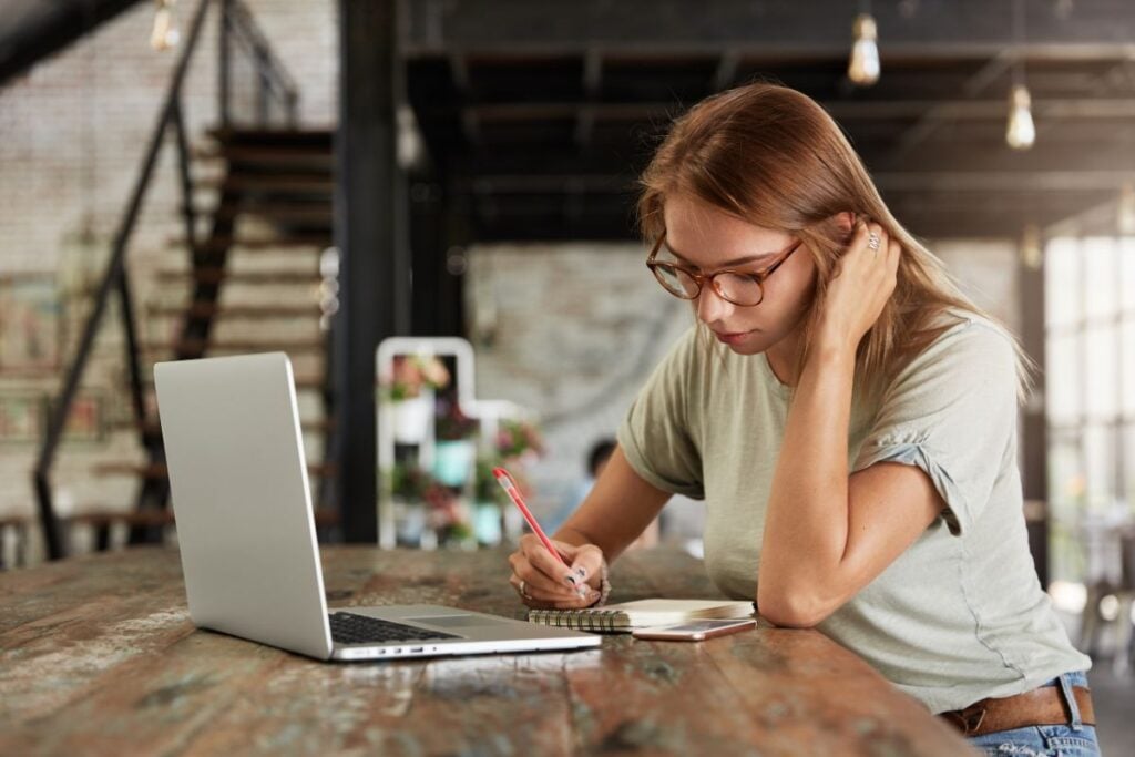 Young blonde woman with glasses in cafe