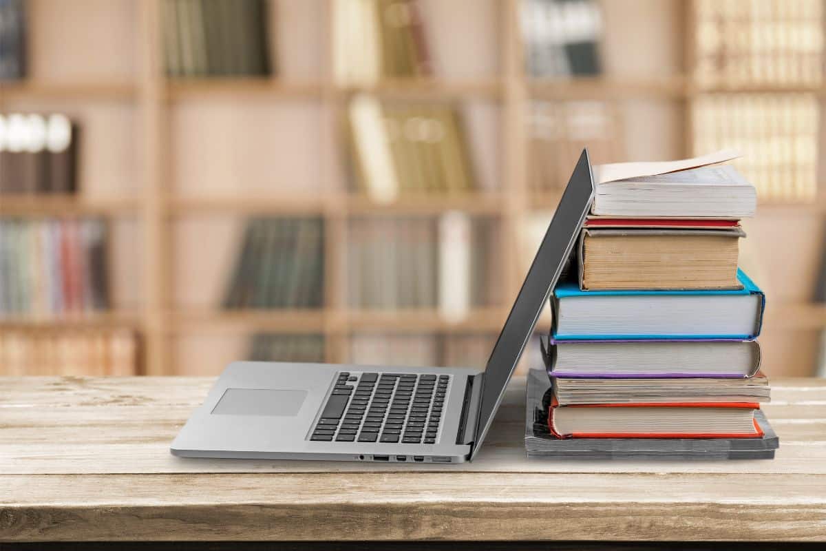 Stack of books and laptop, education and learning background