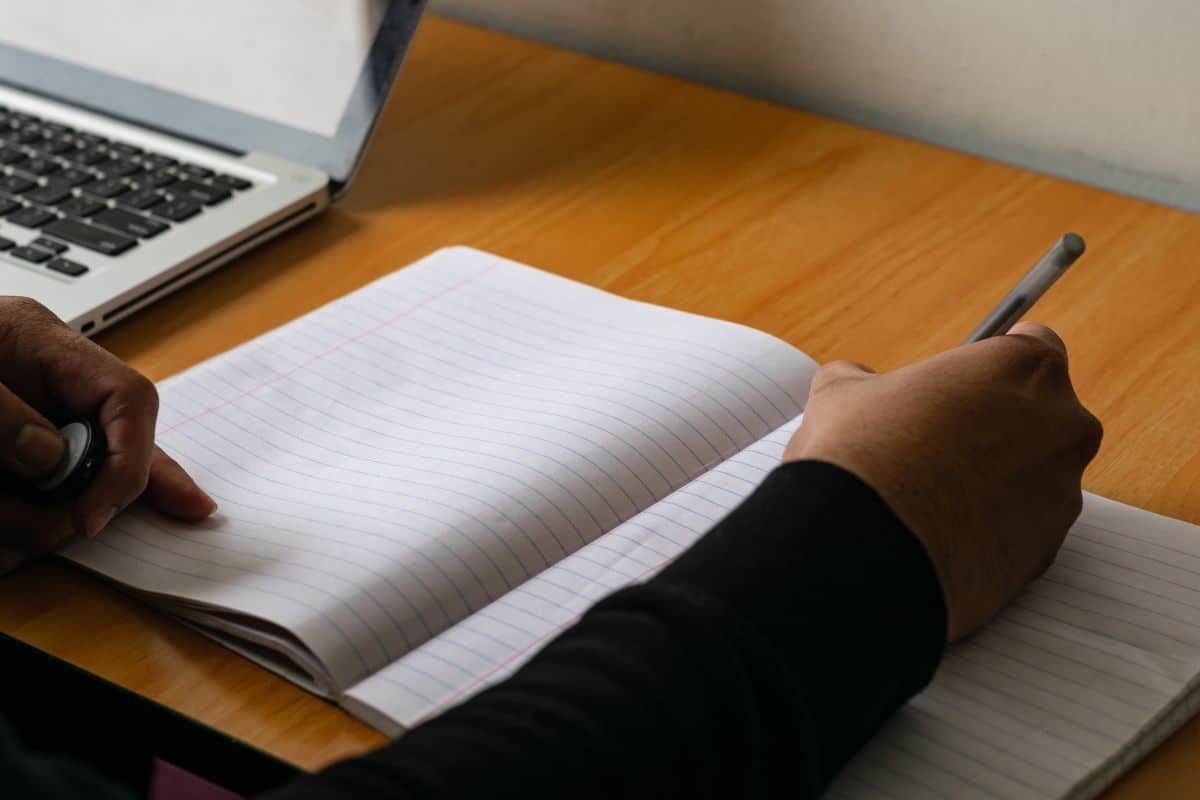 Male hand writing male hand writing with pen on a lined notebook