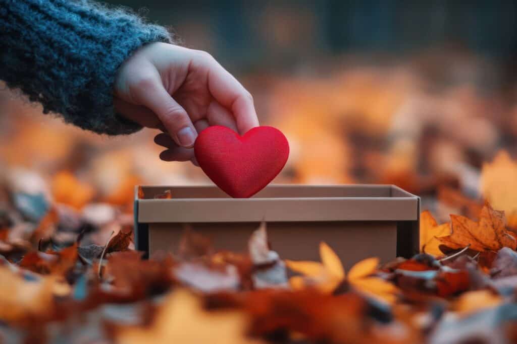 
Autumnal act of kindness a hand gently places a red heart