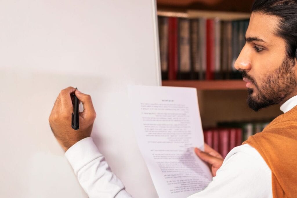 Arab teacher man teaching english language writing grammar rules