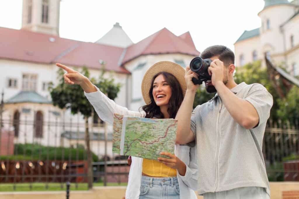 Podekscytowana para turystów zwiedzająca miasto z papierową mapą