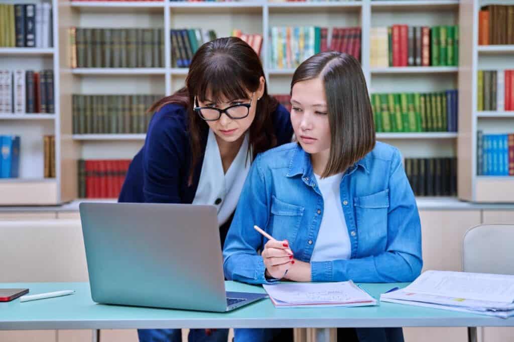 
Female university student with teacher preparing for exam