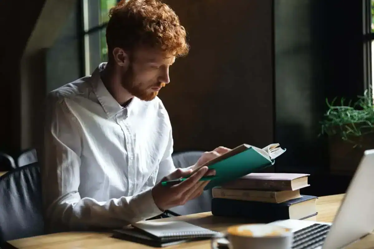 Foto de estudiante pelirrojo concentrado con barba