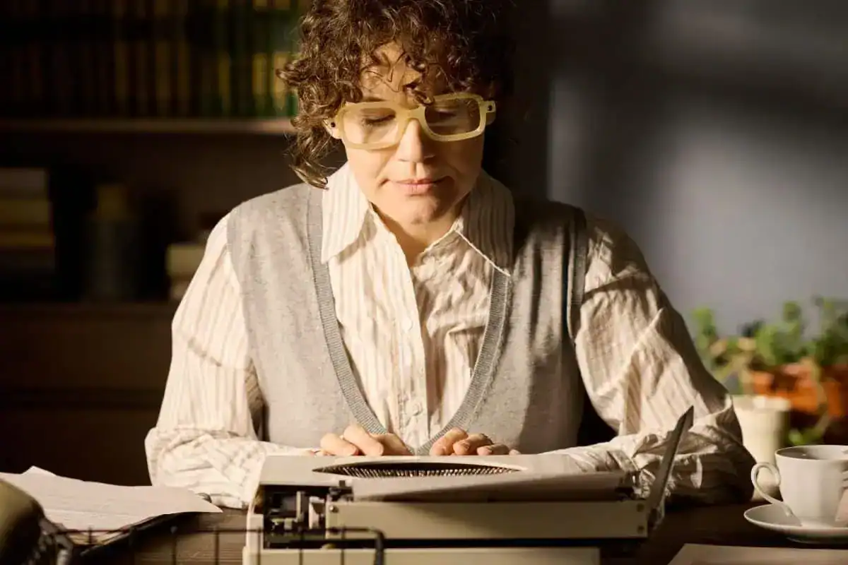 Portrait of young adult caucasian woman typing on typewriter indoors