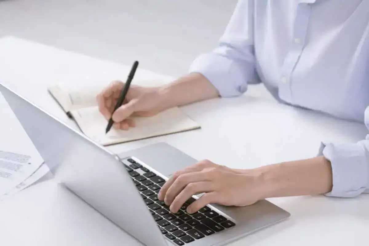 Hand of young businesswoman pushing keys of laptop keypad