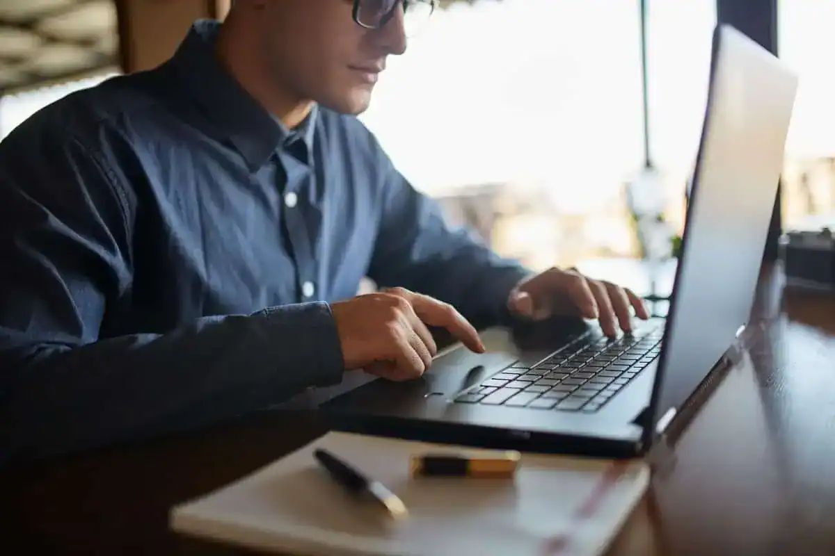 photo of caucasian male hands typing on laptop keyboard