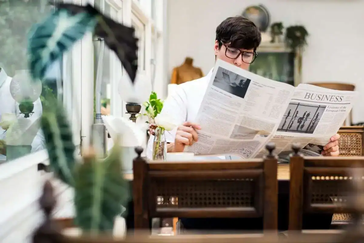 Young man reading newspaper in the morning