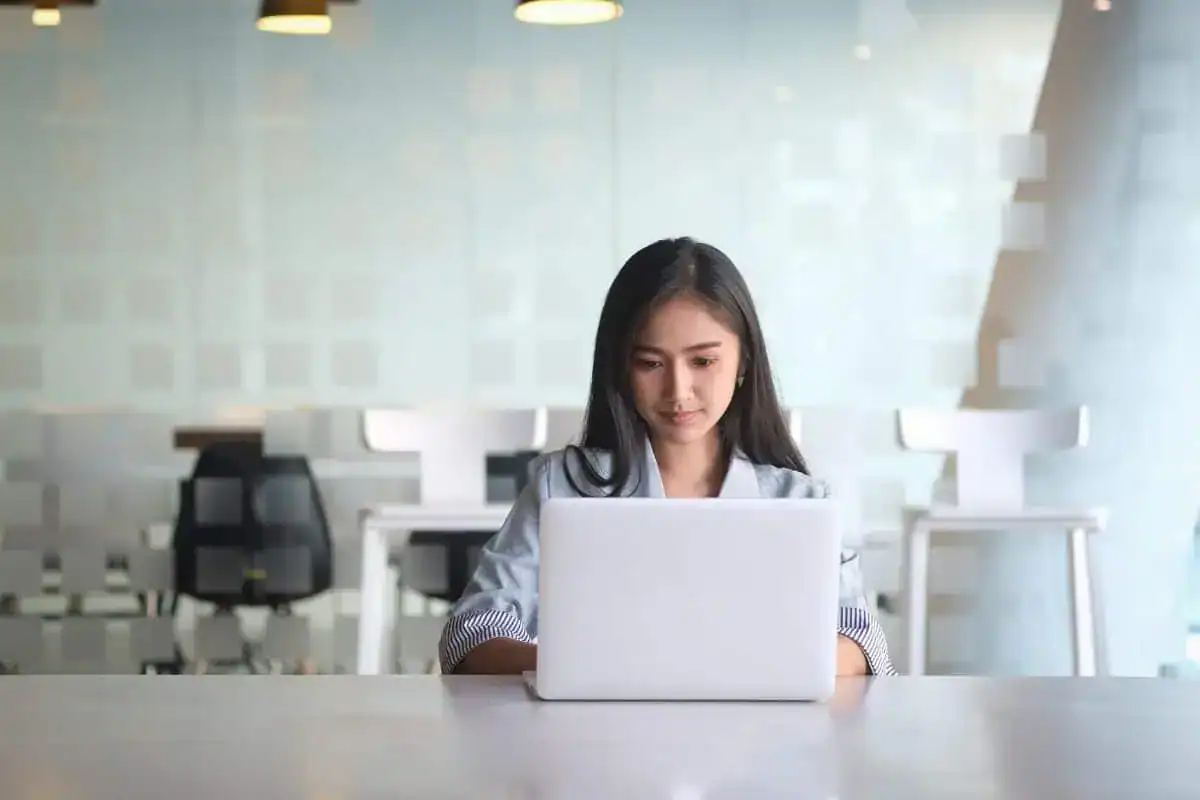 Portrait of woman using phone while sitting on table