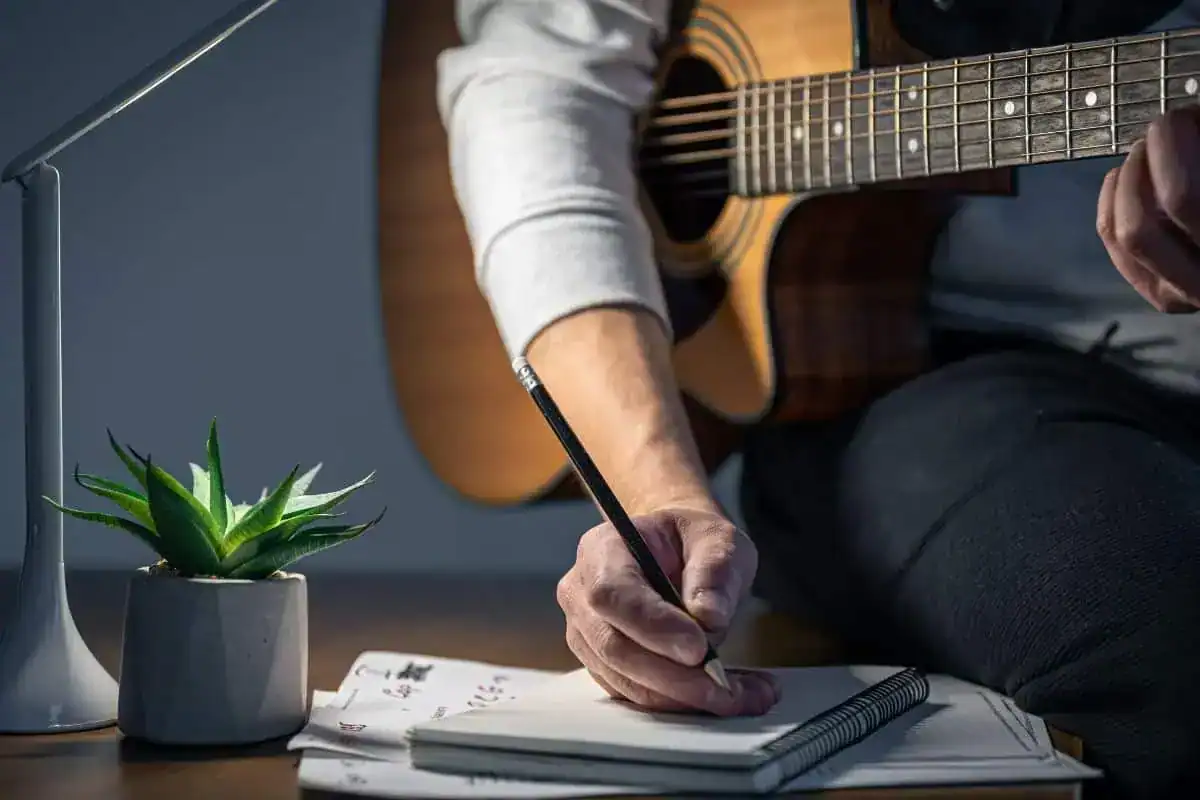 A man with a guitar creates music plays at night
