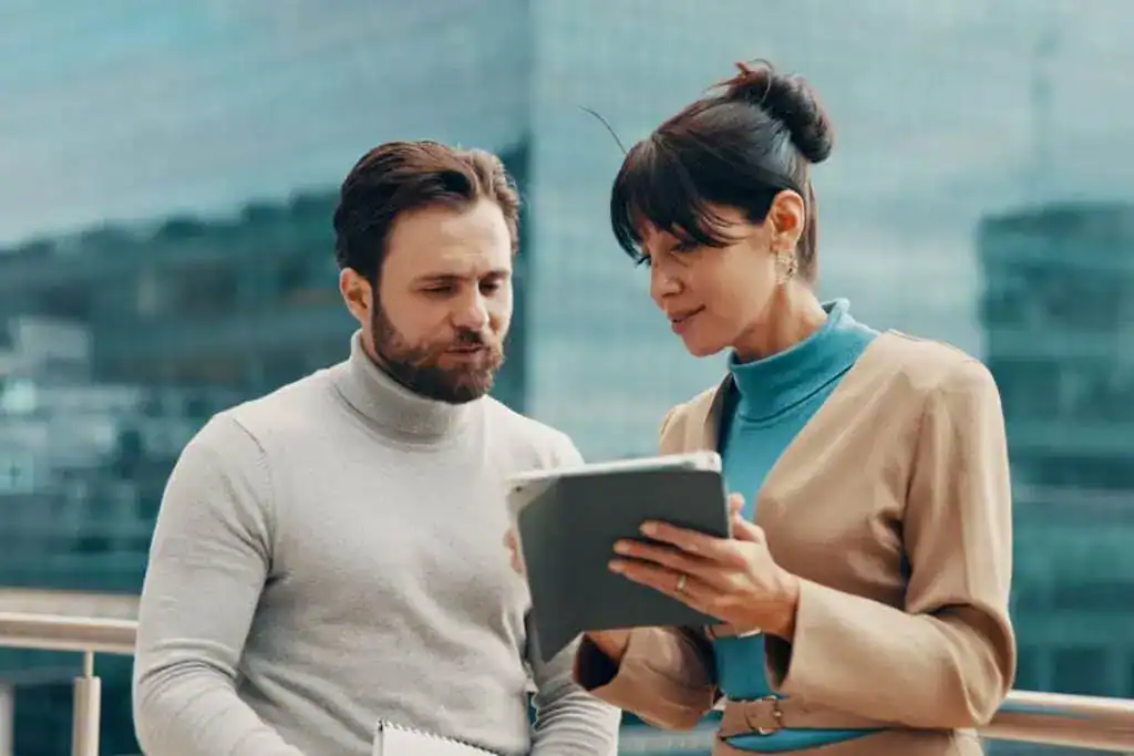 13 formas de utilizar ChatGPT en el trabajo para impulsar tu flujo de trabajo 4 Meeting balcony and business people on tablet