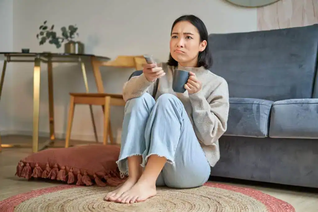 Portrait of girl watching television at home sits on floor