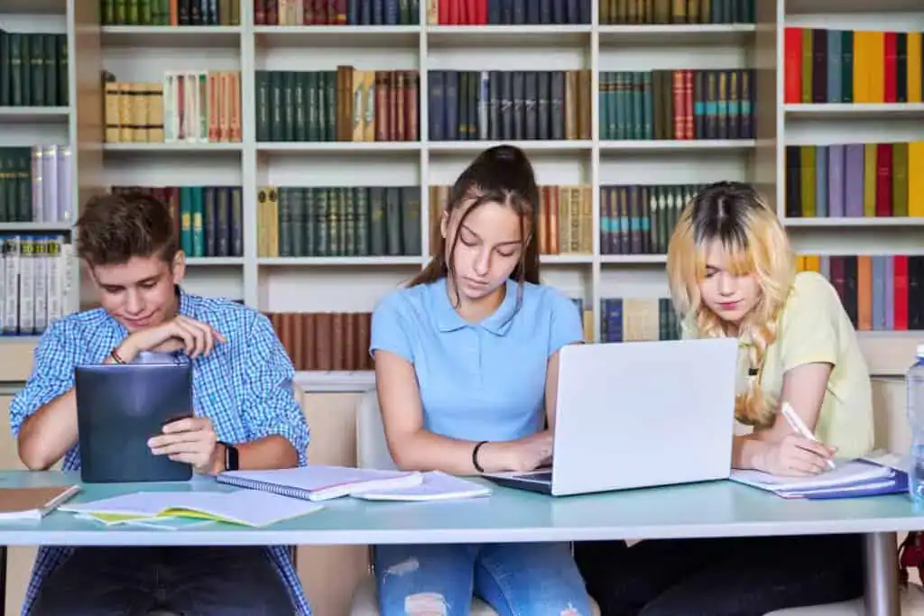 Group of teenage students studying in school library