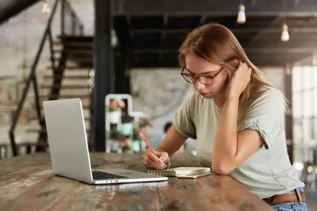 Young blonde woman with glasses in cafe