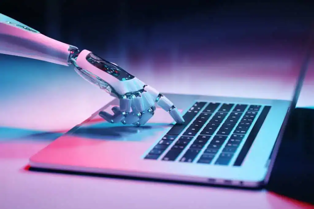 Comment détecter l'écriture AI et la rendre indétectable 4 Rendu 3D d'une main robotisée tapant sur le clavier d'un ordinateur portable