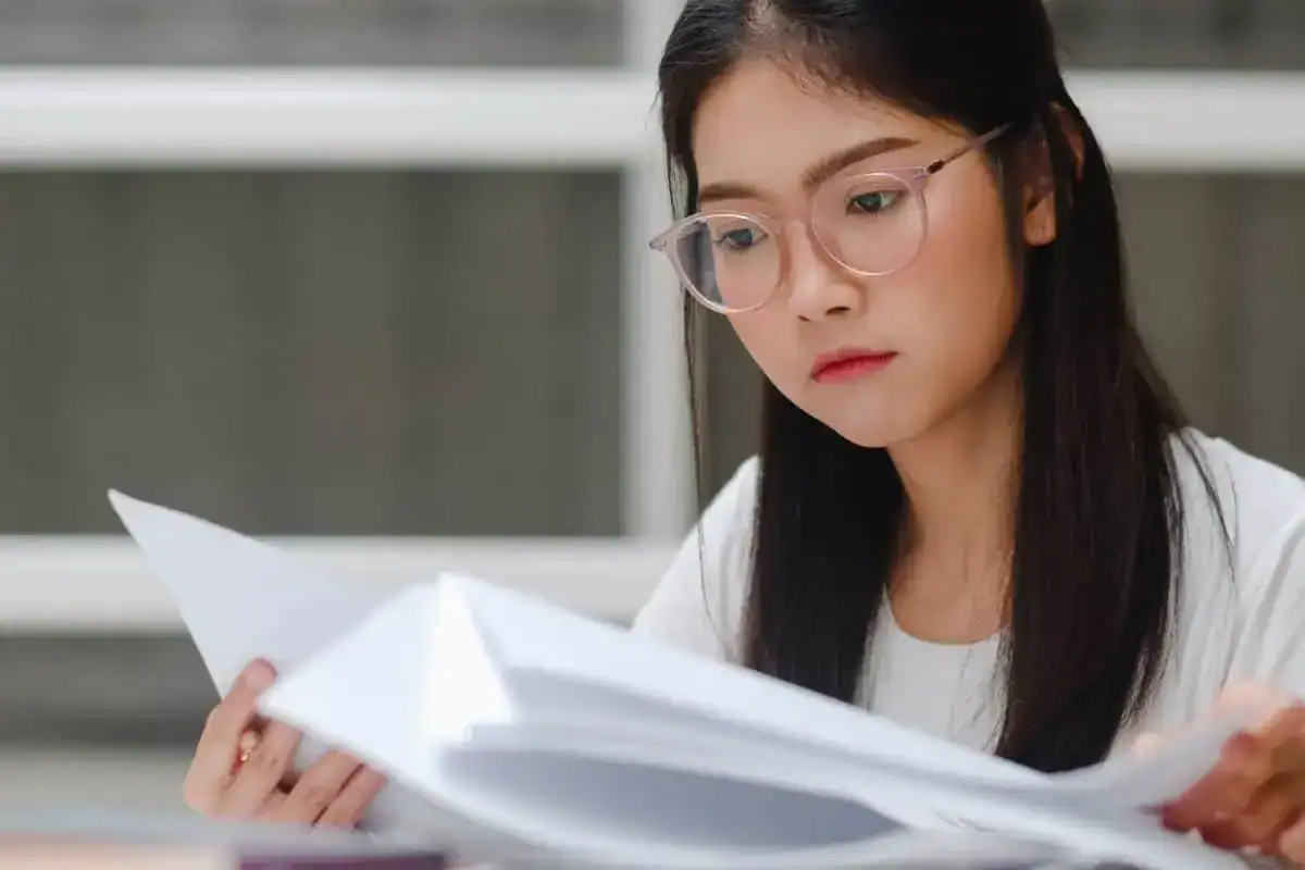 Asian student woman reading books in library at university