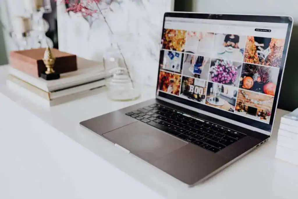 Laptop displaying images on a blog on a white table