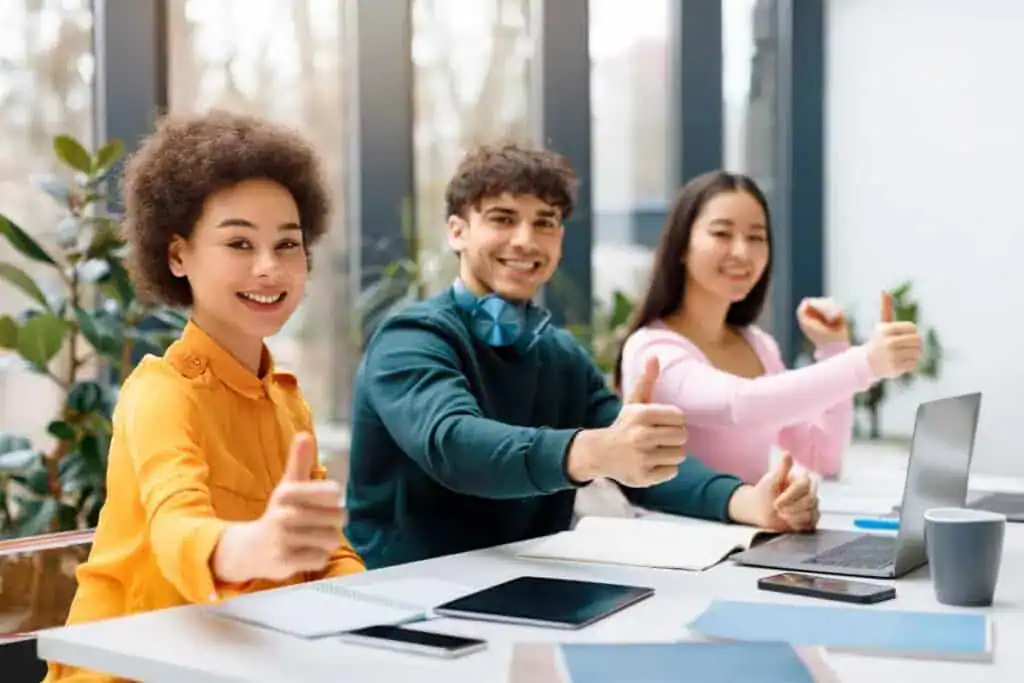 Multicultural students giving thumbs up at study session