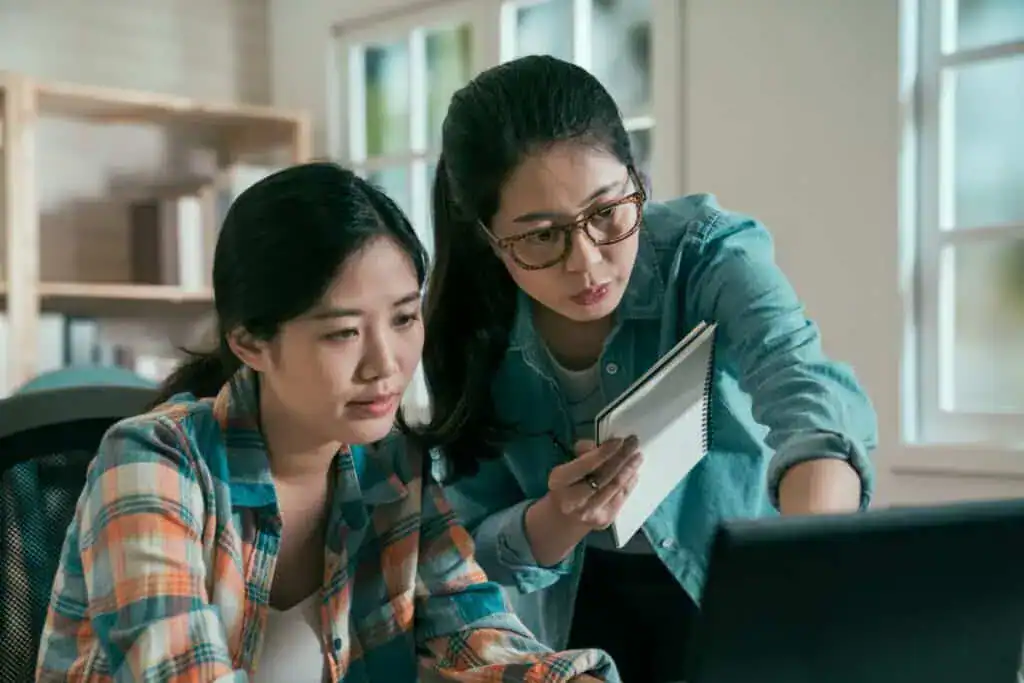 Two asian women colleagues working together with laptop