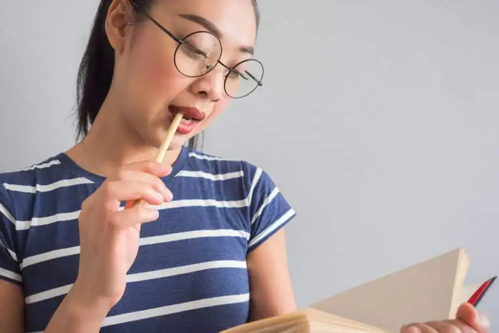 Asian woman reading book and thinking for ideas.