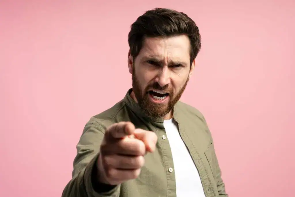 Bearded man standing over pink background 