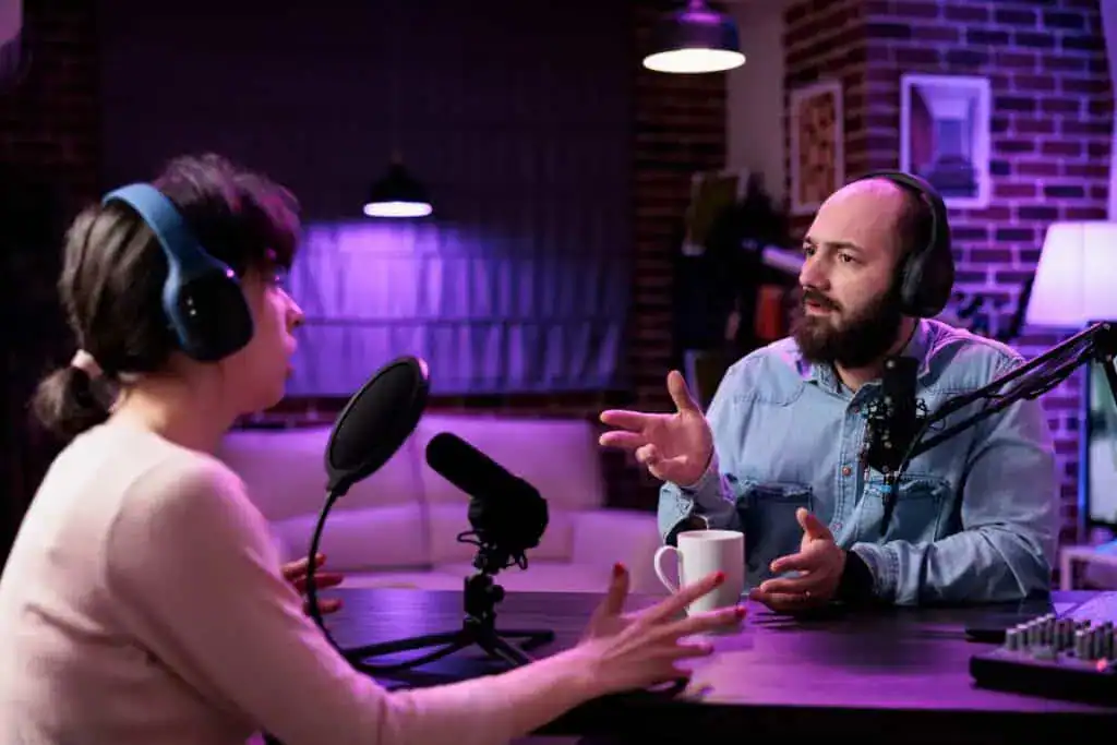 Man and woman creating podcast content online with equipmen
