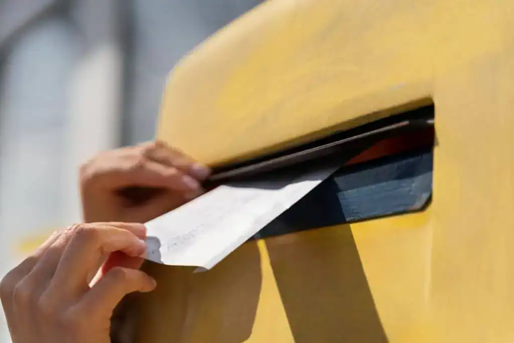 
Close up woman at mailbox with envelope