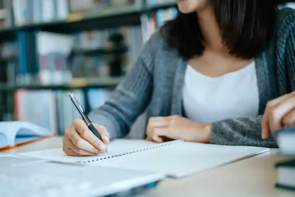 Midsection of woman reading book while sitting on table