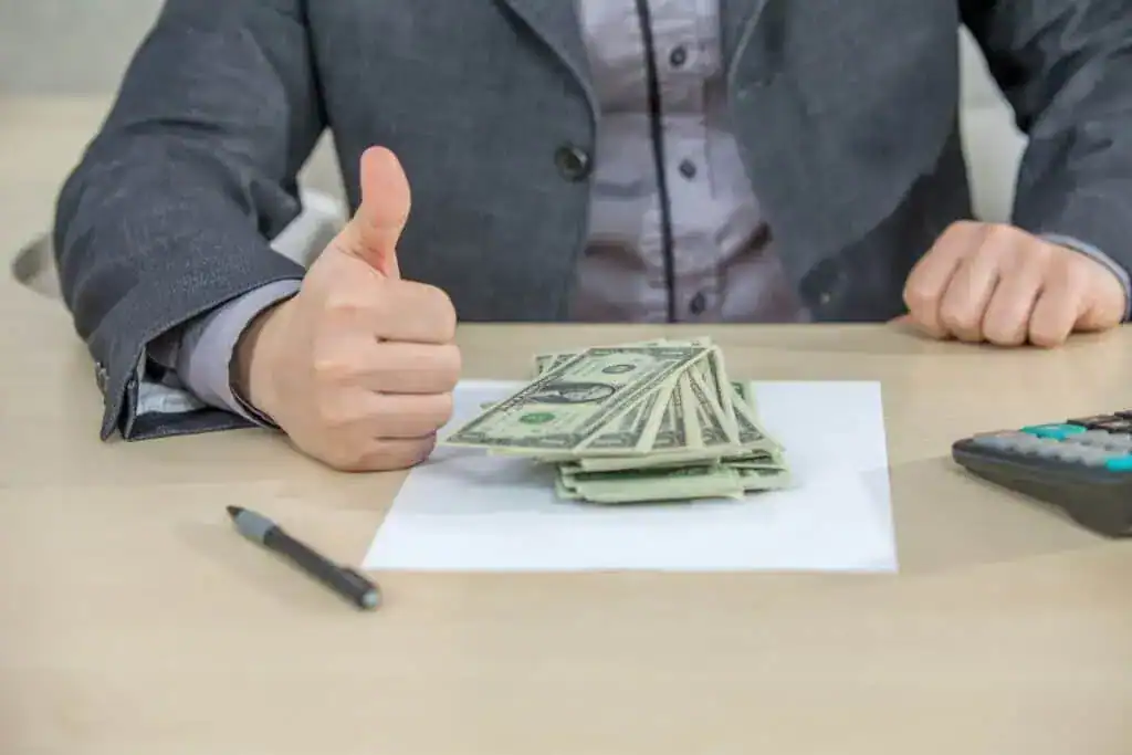 Young businessman working from his office and counting cash money